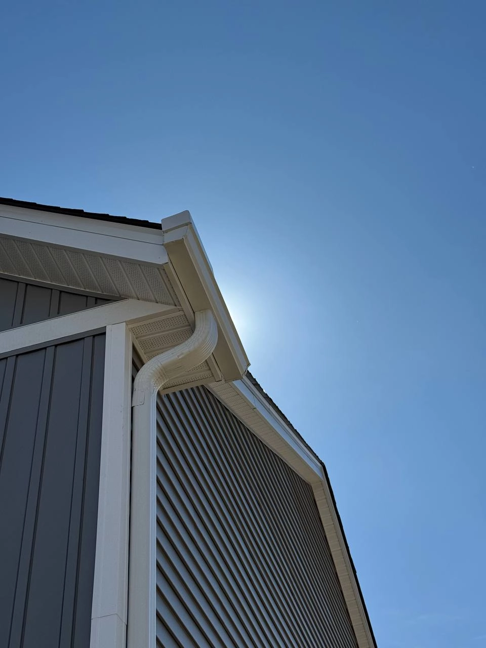 Close-up of seamless gutter corner and downspout on Woodbury home